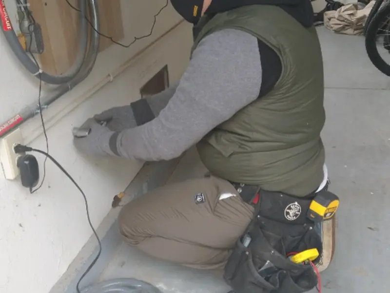 Electrician performing outlet wiring in a Montpelier garage